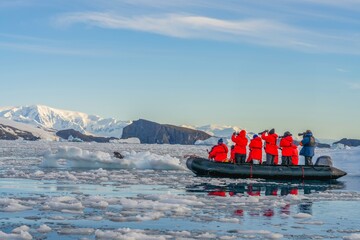 Antarktis Touristen beobachten vom Zodiac aus ganz nah einen Seeleopard (Hydrurga leptonyx) auf einer Eisscholle in der Cierva Cove - obrazy, fototapety, plakaty