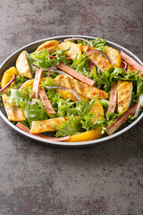 Rhubarb and chicken salad with oranges, onions and lettuce closeup on the wooden board on the table. Vertical