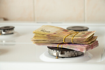 One hundred and two hundred hryvnia lie on a gas stove in the kitchen, Ukrainian hryvnia and gas,...