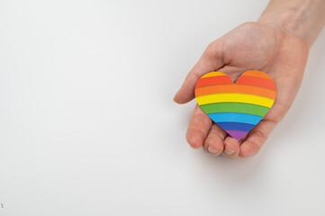 Female hands with rainbow paper heart isolated on white background. Copy space. 