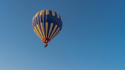 A bright blue-yellow balloon in a clear azure sky. Close-up. Copy Space