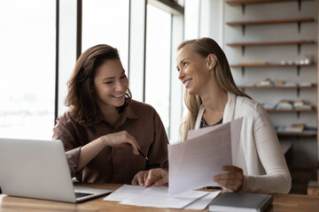 Happy business colleagues analyzing, reviewing project papers, legal documents together. Customer and legal expert meeting at workplace for paperwork. Mentor explaining contract to interns