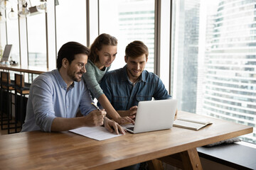 Creative business team sharing laptop in office, watching startup presentation, design project,...