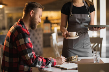 waitress serving coffee to her customer in a cafe, man working in a coffee shop, ordering americano and dessert