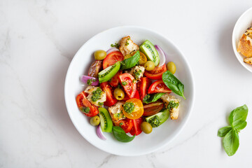 Tomatoes salad top view on light surface