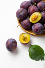 Close up of ripe plum on wooden plate fresh fruits