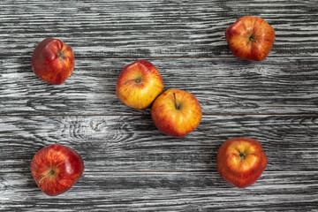Red Delicious apples on a black wooden table.