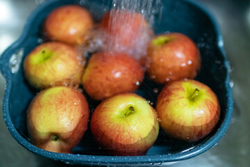 Soaking apple in kitchen sink. Cleaning completely before eating, soaking fruits in water is relatively effective at sanitizing them.