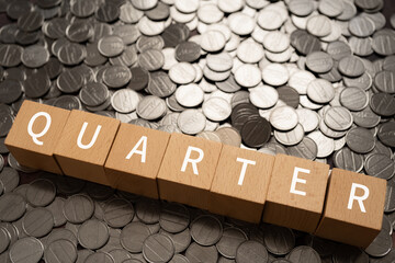 4分の1・クオーターのイメージ｜「QUARTER」と書かれた積み木とコイン