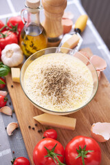 making homemade pasta carbonara - parmesan and cream sauce in a glass bowl