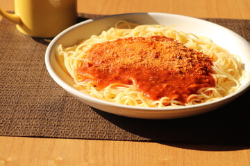 粉チーズを振りかけたミートソースパスタ