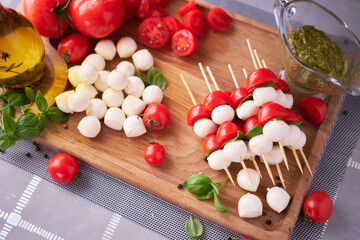 Naklejka na ściany i meble Caprese salad - Mini mozzarella cheese in glass bowl, tomato and basil
