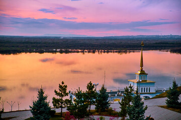 The territory of the tourist complex Zaimka against the background of a bright sunset over the Ussuri River near the city of Khabarovsk. Russia.