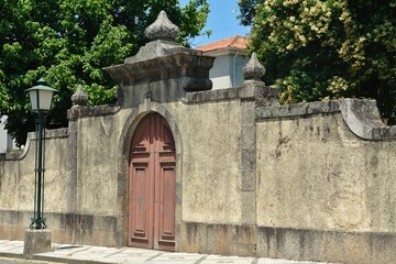 Fototapeta na wymiar Historic wall with wooden gate in Guimaraes, Norte - Portugal 