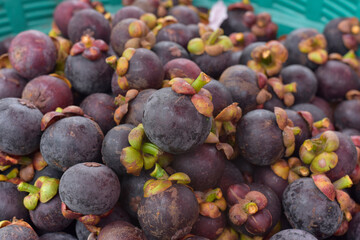 Fresh ripe mangosteen fruits for sale in a supermarket and market at Thailand, queen of fruits, mangosteen is a fruit with white flesh, sweet and delicious. Healthy fruits Red mangosteen background.