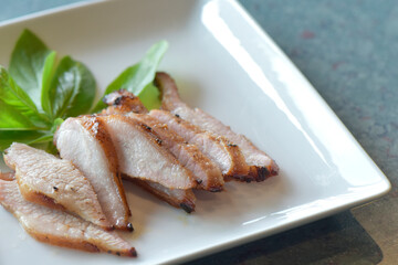 Grilled Pork Neck,  Thai Food. close up Charcoal-boiled Pork Neck on a plate white is a Popular Appetizer in Thailand. selected focus