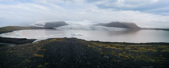 Glacier tongue end with lake and icebergs panorama