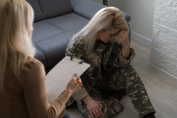 Psychologist making notes during therapy session with soldier, PTSD