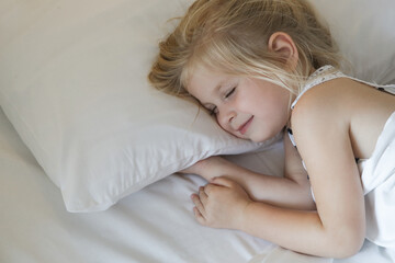 Obraz na płótnie Canvas Sweet little girl sleeping in the bed