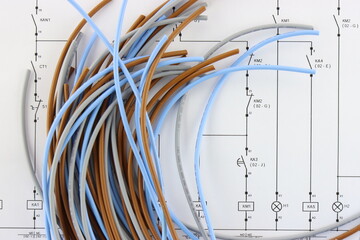 Colored copper wires on an electrical diagram in close-up.
