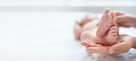Mother and her newborn baby on bed, closeup view with space for text. Banner design