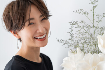 カメラ目線のきれいなお花と美しい日本人女性のポートレート	

