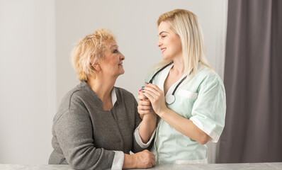 Health visitor and a senior woman during home visit.