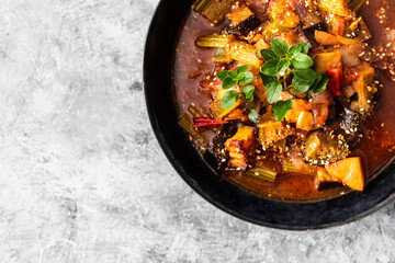 healthy plant-based food, vegan turkish güveç hot pot with eggplant celeri and potaotes in spicy broth with mixed herbs