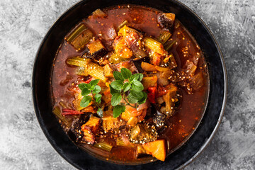 healthy plant-based food, vegan turkish güveç hot pot with eggplant celeri and potaotes in spicy broth with mixed herbs