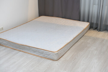 gray mattress in the room near the wall