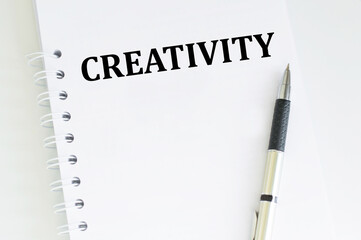 Creativity text on a notepad page on the table