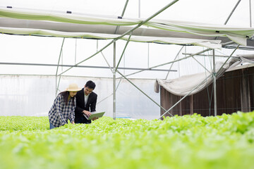 Quality inspector and female farmer at hydroponics farm.