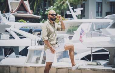 Portrait of a fashion young man posing at marina and yahts background