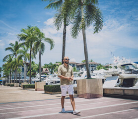 Portrait of a fashion young man posing at marina and yahts background