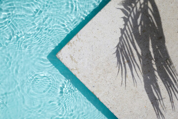 Swimming pool top view background. Water ring and palm shadow on travertine stone - obrazy, fototapety, plakaty