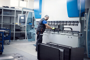 A smart factory worker or engineer makes machines in a production workshop. The concept of industry and engineering. Selective focus