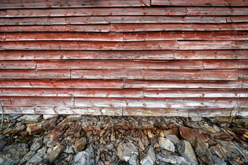 Facade of an old wooden building of Scandinavian type with red wooden boards