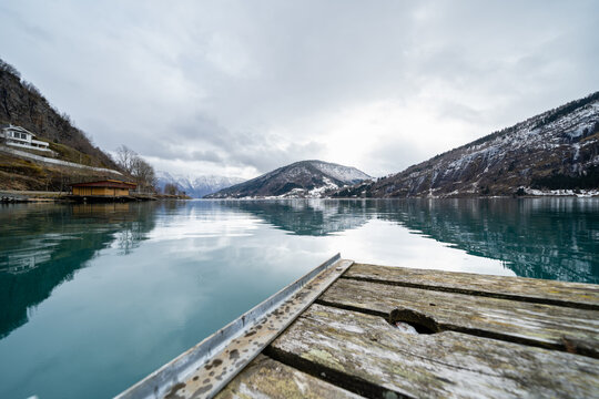 A beautiful old wooden footbridge in the Norwegian fjord overlooking the mountains © Rolands