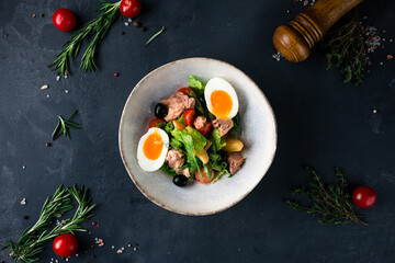French salad Nicoise with tuna, eggs, green beans, tomatoes, olives, lettuce