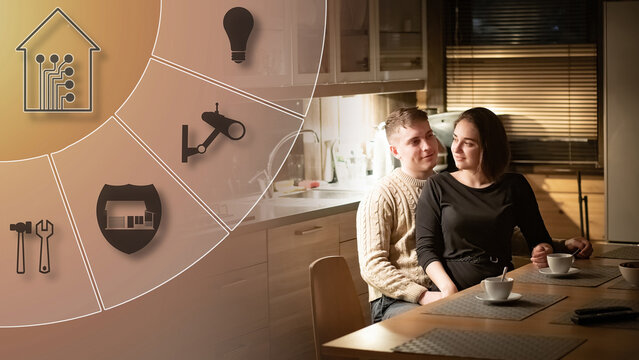 Smart home technology. Young family is sitting at table. Young family in smart home. Smart home technology symbols near couple in love. Man and woman in cottage kitchen. IOT system in house