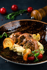 Traditional German braised beef cheeks in brown red wine sauce with spaetzle herbs
