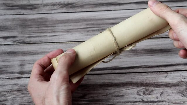 Man is holding an ancient scroll. Medieval manuscript.