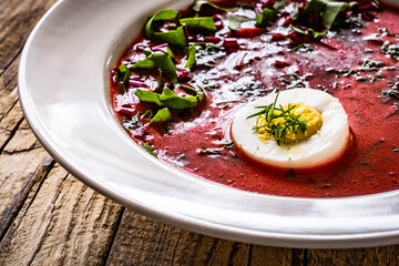 Borsch - beetroots soup with egg on wooden table

