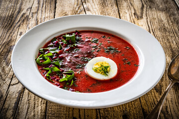 Borsch - beetroots soup with egg on wooden table

