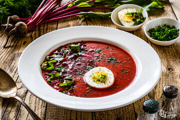 Borsch - beetroots soup with egg on wooden table

