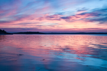 Fototapeta na wymiar Blue pink magnificent sunset above a mirror water lake in Sweden