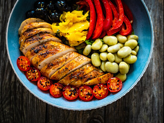 Keto diet - roasted chicken breast and vegetables on wooden table
