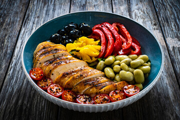 Keto diet - roasted chicken breast and vegetables on wooden table
