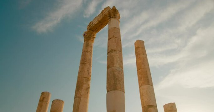 Amman Citadel - landmark archeological site in downtown Amman, capital of Jordan, Middle East. Ruins of Temple of Hercules - ancient roman architecture. 4K low angle orbit shot in slow motion