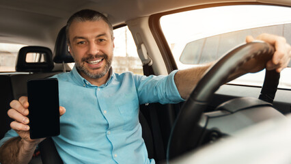 Happy driver using showing smartphone with empty screen